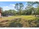 Expansive backyard featuring mature trees and a tranquil screened-in pool at 6080 Dexter Ln, Brooksville, FL 34602