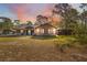 Charming single-story home with a welcoming front porch and picturesque sunset backdrop at 6080 Dexter Ln, Brooksville, FL 34602