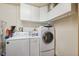 Functional laundry room with washer, dryer, and overhead storage cabinets at 6080 Dexter Ln, Brooksville, FL 34602