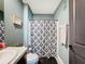 Nicely decorated bathroom featuring granite counters and a modern patterned shower curtain at 6561 Seaway Dr, Brooksville, FL 34604