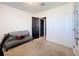 Simple bedroom with neutral carpet and an adjacent dark-colored door at 6561 Seaway Dr, Brooksville, FL 34604