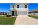 Two-story home with a large driveway and a two-car garage, along with manicured landscaping at 6561 Seaway Dr, Brooksville, FL 34604