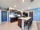 Modern kitchen with a center island, breakfast bar, black appliances, and tile floors at 6561 Seaway Dr, Brooksville, FL 34604