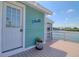 Waterfront home with a turquoise exterior, white door, and inviting outdoor deck at 6622 Seaview Blvd, Hudson, FL 34667