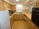 Galley kitchen featuring wood cabinets, laminate countertops, and retro flooring at 6636 Timbercove Ln # 6636, New Port Richey, FL 34653