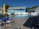 Outdoor swimming pool surrounded by a lounge area, fencing, and lawn chairs at 6636 Timbercove Ln # 6636, New Port Richey, FL 34653