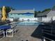 Outdoor swimming pool with lounge area, white fencing, lounge chairs, and shade sails at 6636 Timbercove Ln # 6636, New Port Richey, FL 34653