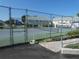 View of the community tennis courts, featuring a fenced enclosure, smooth walkways, and well-maintained greenery at 6636 Timbercove Ln # 6636, New Port Richey, FL 34653