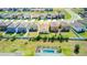 Neighborhood aerial showcasing well-kept lawns with white fences, lush greenery and the luxury of a screened-in pool at 680 Argyll Dr, Spring Hill, FL 34609