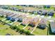 Aerial view of the neighborhood with neat homes, lush green lawns, and a playground in the spacious backyard at 680 Argyll Dr, Spring Hill, FL 34609