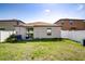 Backyard features a lawn and sliding glass doors leading into the home at 680 Argyll Dr, Spring Hill, FL 34609