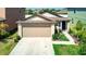 Exterior view of the home showcasing its two-car garage, manicured lawn, and inviting entrance at 680 Argyll Dr, Spring Hill, FL 34609