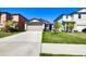 Exterior view of the home featuring a two-car garage, long driveway, and landscaped front yard at 680 Argyll Dr, Spring Hill, FL 34609