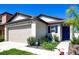 Charming single-Gathering home featuring a two-car garage, manicured landscaping, and a vibrant blue front door at 680 Argyll Dr, Spring Hill, FL 34609