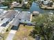 Aerial view showcases the neighborhood's canal and home with a tiki hut in the backyard at 6816 Sanderling Ln, Hudson, FL 34667