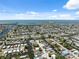 Aerial view showcasing a waterfront community with canals, residential homes, and access to the open bay at 6816 Sanderling Ln, Hudson, FL 34667