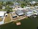Aerial view of a waterfront property with a tiki hut, dock, and canal access at 6816 Sanderling Ln, Hudson, FL 34667