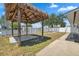 Backyard featuring a tiki hut, concrete patio and partial view of fenced yard at 6816 Sanderling Ln, Hudson, FL 34667