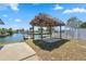 Backyard featuring a tiki hut overlooking the canal and dock on a sunny day at 6816 Sanderling Ln, Hudson, FL 34667