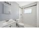 Bright bathroom featuring white tile in the shower, vanity with sink, and a modern mirror at 6816 Sanderling Ln, Hudson, FL 34667
