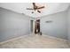Bedroom with plank flooring, neutral walls, a ceiling fan, and an open doorway at 6816 Sanderling Ln, Hudson, FL 34667