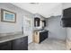 Compact kitchen featuring dark cabinetry, ample countertop space, and rear door access at 6816 Sanderling Ln, Hudson, FL 34667