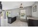 Kitchen boasts an island, granite countertops, dark cabinetry, and a view of the water at 6816 Sanderling Ln, Hudson, FL 34667