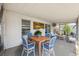 Screened patio with dining and seating areas featuring blue and white decor at 6816 Sanderling Ln, Hudson, FL 34667