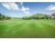 Manicured greens of the golf course under a beautiful blue sky at 7529 Greystone Dr # A, Hudson, FL 34667