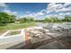 Outdoor patio area with white concrete picnic tables and lush green golf course views at 7529 Greystone Dr # A, Hudson, FL 34667