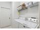 Laundry room with washer, dryer, shelving, and convenient access to the door at 8445 Gallup Rd, Spring Hill, FL 34608
