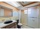 Bathroom featuring a vanity with marble countertop and tiled shower with swan etched shower door at 9001 Lido Ln, Port Richey, FL 34668