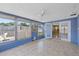 Bright enclosed Florida room with sliding glass doors, tile floor and view of fenced-in yard at 9001 Lido Ln, Port Richey, FL 34668