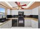 Kitchen featuring stainless steel sink, dishwasher, black appliances and white cabinets at 9001 Lido Ln, Port Richey, FL 34668