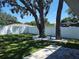 Spacious backyard featuring lush green lawn, mature trees, stone pavers, and a white privacy fence at 9089 Dupont Ave, Spring Hill, FL 34608