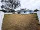 Wide view of backyard shows fence, large green lawn, and view of back of house at 9089 Dupont Ave, Spring Hill, FL 34608