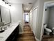 Well-lit bathroom featuring double vanity, modern fixtures, and convenient hallway access at 9089 Dupont Ave, Spring Hill, FL 34608