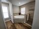 Bright bathroom with a large soaking tub, tiled shower with seat, and wood-look tile flooring at 9089 Dupont Ave, Spring Hill, FL 34608