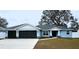 Charming home with a two-car garage, light-blue siding, dark roof, and well-manicured lawn at 9089 Dupont Ave, Spring Hill, FL 34608
