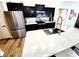 Modern kitchen featuring black cabinets, stainless steel appliances, and a spacious quartz countertop island at 9089 Dupont Ave, Spring Hill, FL 34608