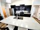Bright kitchen with modern appliances, dark cabinets, and a large island with seating, perfect for entertaining at 9089 Dupont Ave, Spring Hill, FL 34608