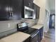 Modern kitchen featuring stainless steel appliances, dark cabinets, and light countertops at 9089 Dupont Ave, Spring Hill, FL 34608