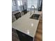 Close-up of the kitchen island, featuring a stainless sink, stone countertops, and sleek cabinetry at 9089 Dupont Ave, Spring Hill, FL 34608