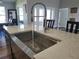 Close-up kitchen island with stainless steel sink and faucet, stone countertops, and seating at 9089 Dupont Ave, Spring Hill, FL 34608