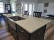 View of kitchen island highlighting stone countertops, sink, faucet, cabinets and seating in a well-lit space at 9089 Dupont Ave, Spring Hill, FL 34608