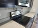 Stainless steel range with sleek black cooktop and dark cabinets, in modern kitchen with light countertops at 9089 Dupont Ave, Spring Hill, FL 34608