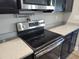 Modern kitchen range with stainless steel appliances and sleek black cooktop and dark cabinets at 9089 Dupont Ave, Spring Hill, FL 34608