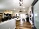 Open-concept living space with wood floors, a ceiling fan, and seamless flow to the kitchen and dining areas at 9089 Dupont Ave, Spring Hill, FL 34608