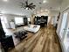Open-concept living room featuring modern decor, high ceilings, wood-look floors, and lots of light at 9089 Dupont Ave, Spring Hill, FL 34608