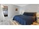 Cozy bedroom featuring a queen-sized bed, wood floors, and natural light from the window at 9100 Whitman Ln, Port Richey, FL 34668